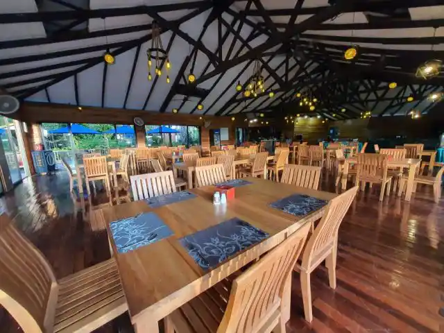 Spacious open-air dining hall at Borneo Divers Mabul Resort, with its impressive vaulted beam ceiling and wooden furniture, ready to welcome hungry divers.