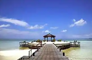 Picturesque pier and sun shelter at Kapalai Resort, an iconic spot on the luxury water village for watching the sunset over the Celebes Sea.