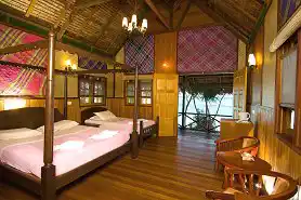 Spacious and charming island room at Lankayan Resort, featuring four-poster beds and a private balcony with beautiful ocean views.