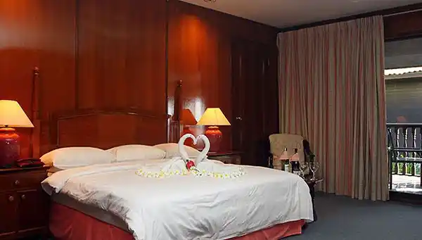 Romantic welcome in a luxury room at Layang Layang Resort, with towels folded into swans and sparkling wine ready for a honeymoon celebration.