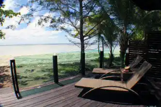 Peaceful seaview from the private deck of a Beach Chalet at Mataking Island, with sun loungers overlooking the shallow turquoise reef.