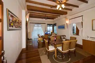 Spacious and elegant living room of the Borneo Villa Suite at Mabul Water Bungalows, offering panoramic ocean views for a luxurious stay.
