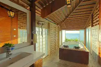 Incredible luxury bathroom in the Bougainvilla chalet, featuring a large jacuzzi tub with an open-air panoramic view of the ocean.