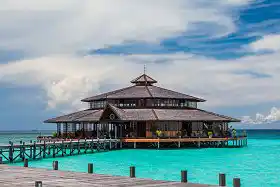Iconic overwater Calyx Restaurant at Pom Pom Island Resort, a stunning location for dining with panoramic views of the turquoise sea.