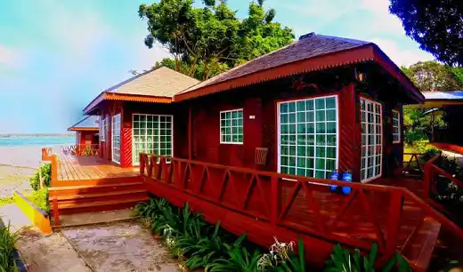 Beautiful red wooden chalet with a large deck at the Scuba Tiger Semporna Holiday Resort, offering budget-friendly accommodation.