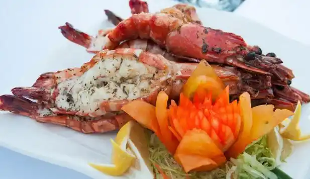 Deliciously grilled fresh tiger prawns served on a platter at the seafood restaurant of the 5-star Pom Pom Island Resort.