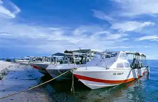 Fleet of resort dive boats moored at the beach, ready to take divers from Sipadan-Mabul Resort dive center to explore the islands.