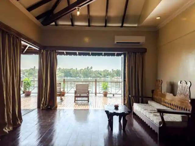 Spacious Deluxe Cottage interior at Sipadan Water Village flows onto a sea-view deck where divers and snorkelers unwind between adventures.