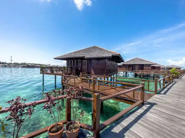 Row of Grand Deluxe over-water chalets at Sipadan Water Village gives snorkelers and divers easy boardwalk access to Sabah's vibrant reefs.