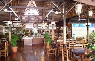 Spacious, open-air restaurant at Sipadan-Mabul Resort (SMART), featuring a high wooden-beamed ceiling and a central buffet for guests.