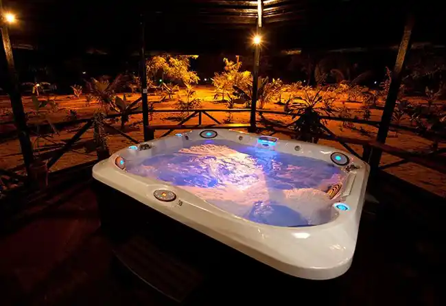 Relaxing in the illuminated outdoor jacuzzi at night at the Yin & Yang Spa, a luxurious amenity at the 5-star Pom Pom Island Resort.