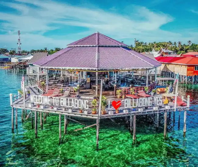 Welcoming main deck and restaurant of Billabong Scuba, an affordable backpacker dive lodge sitting over the vibrant turquoise waters of Mabul Island.
