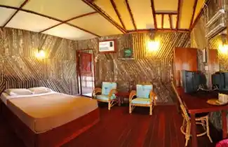 Cozy room inside the Dragon Inn floating hotel in Semporna, featuring unique walls and traditional Bajau-style architecture for a budget stay.