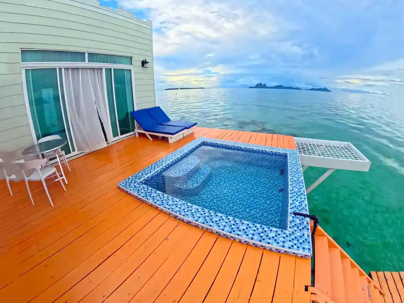 Private overwater balcony at Danglai Resort featuring a personal plunge pool, lounge chairs, and a stunning view of Bohey Dulang.