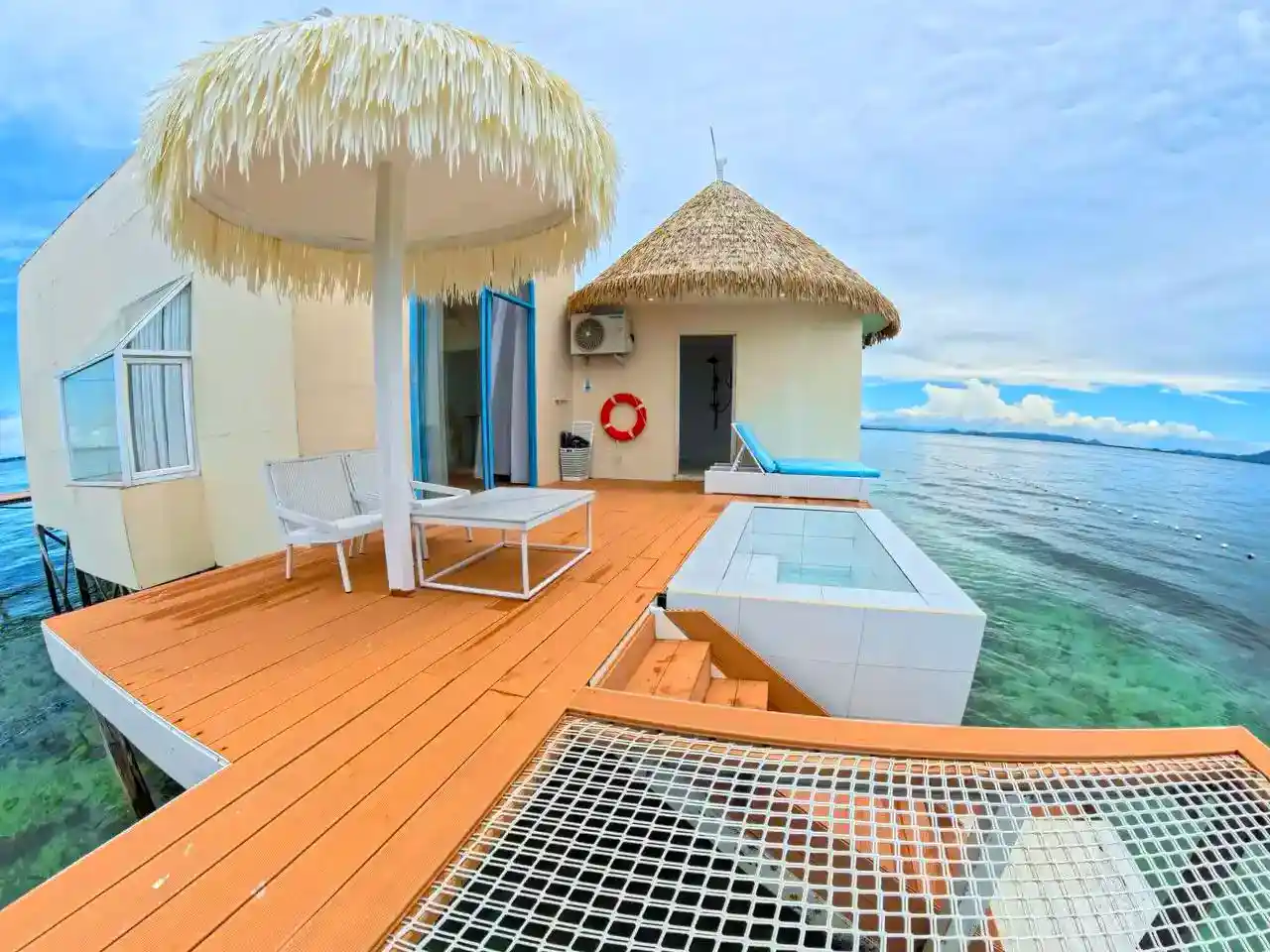 Expansive private balcony at Royal Resort Semporna, featuring a plunge pool, over-water net hammock, and a thatched umbrella for ultimate relaxation.