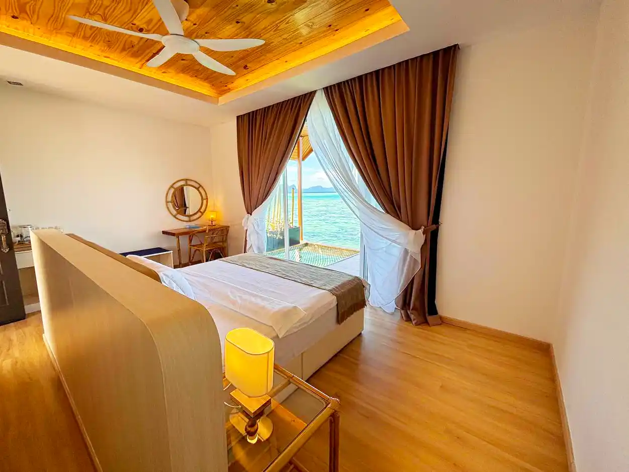 Waking up to a beautiful sea view from a comfortable bed in a Sand Bay Resort room, with a private over-water hammock just outside the door.