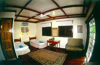 Spacious chalet room at Sipadan-Mabul Resort, with a twin bed layout and sitting area perfect for a family diving holiday.