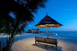 Experience the serene magic of Mabul Island at night. A peacefully lit bench on the white sand beach offers the perfect spot to unwind after a day of incredible diving.