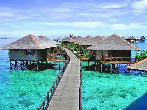 Walk the jetty through your own private paradise at Sipadan Water Village, where beautiful overwater bungalows stand above a crystal-clear turquoise reef on Mabul Island.